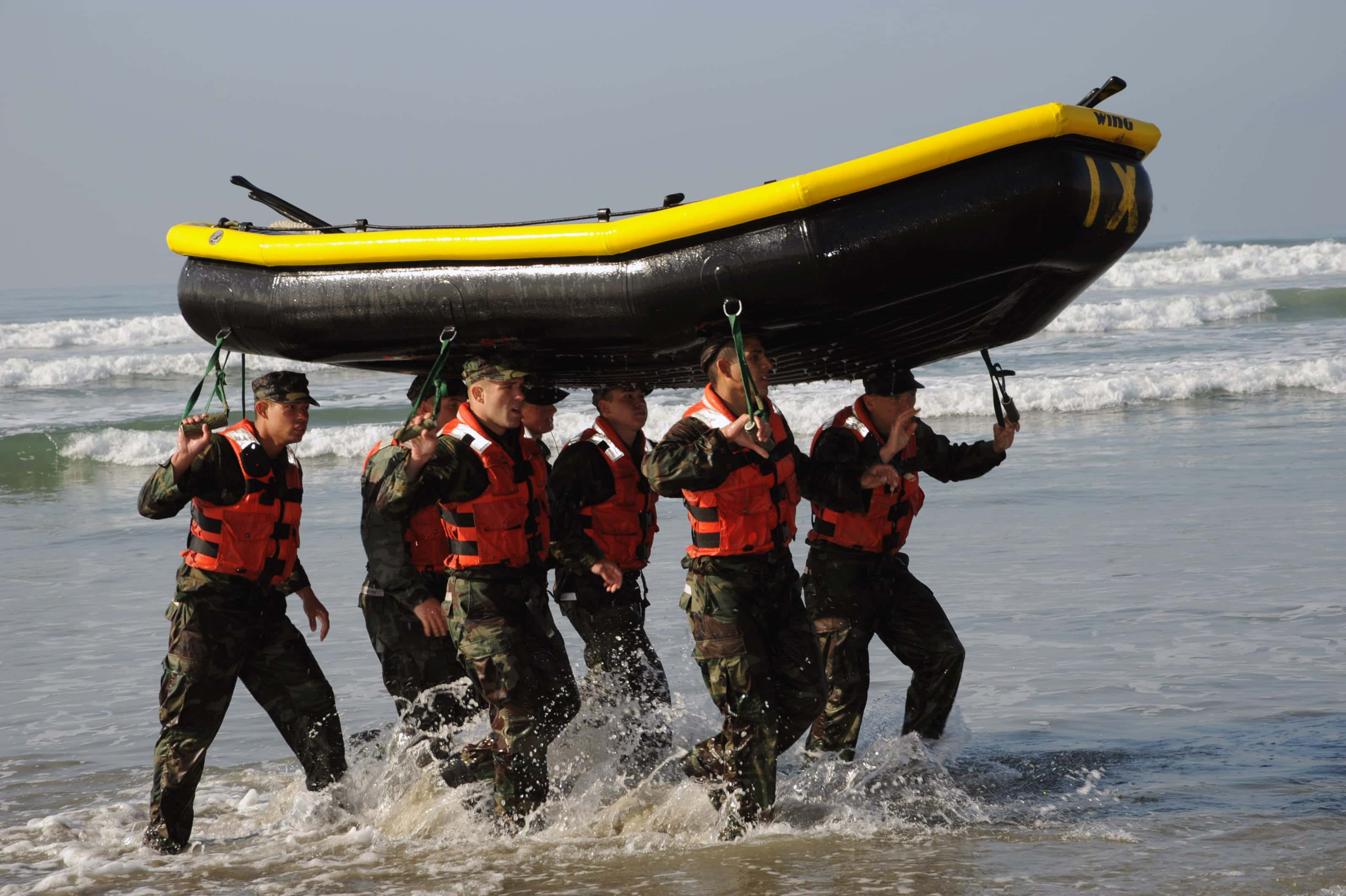 A Navy SEAL team moving together through the water during a cohesion exercise