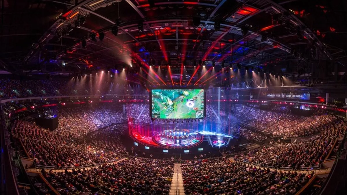Packed stadium at the League of Legends World Championship with a lit stage and a giant screen