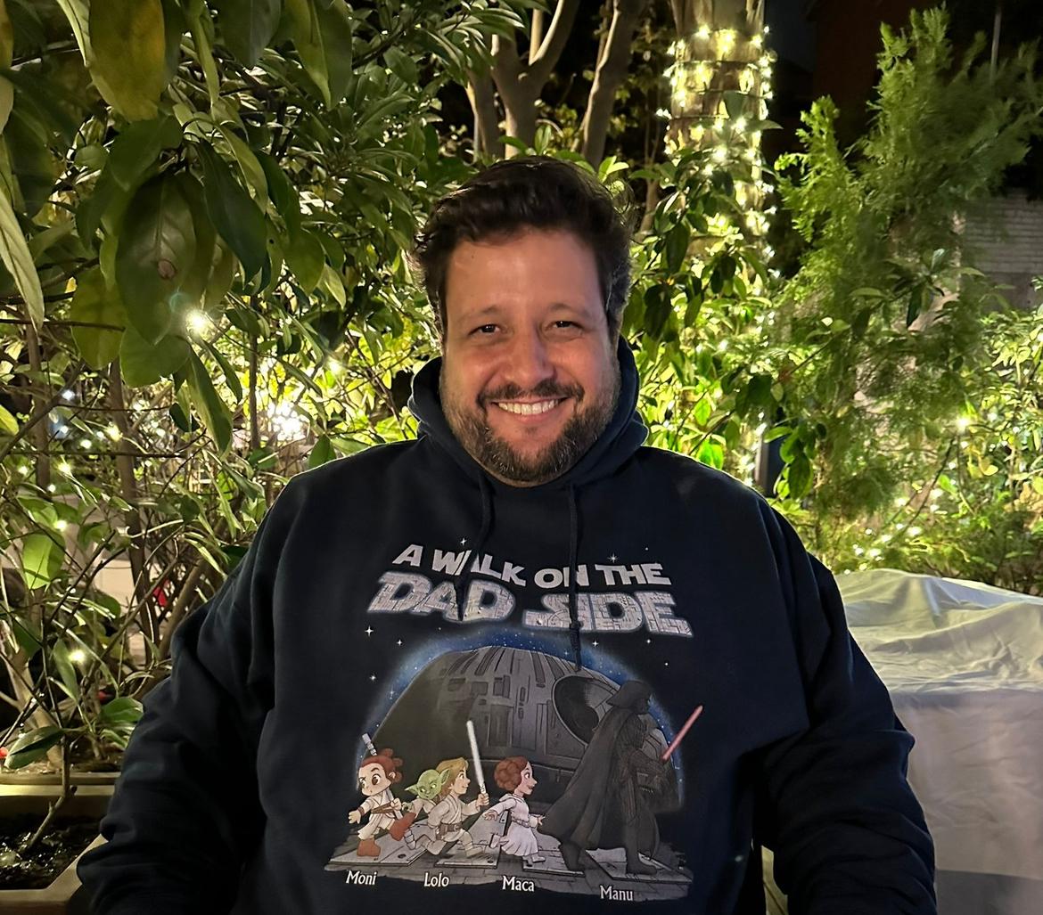 Manu Soriano smiling in a nighttime garden wearing a Star Wars A Walk on the Dad Side hoodie