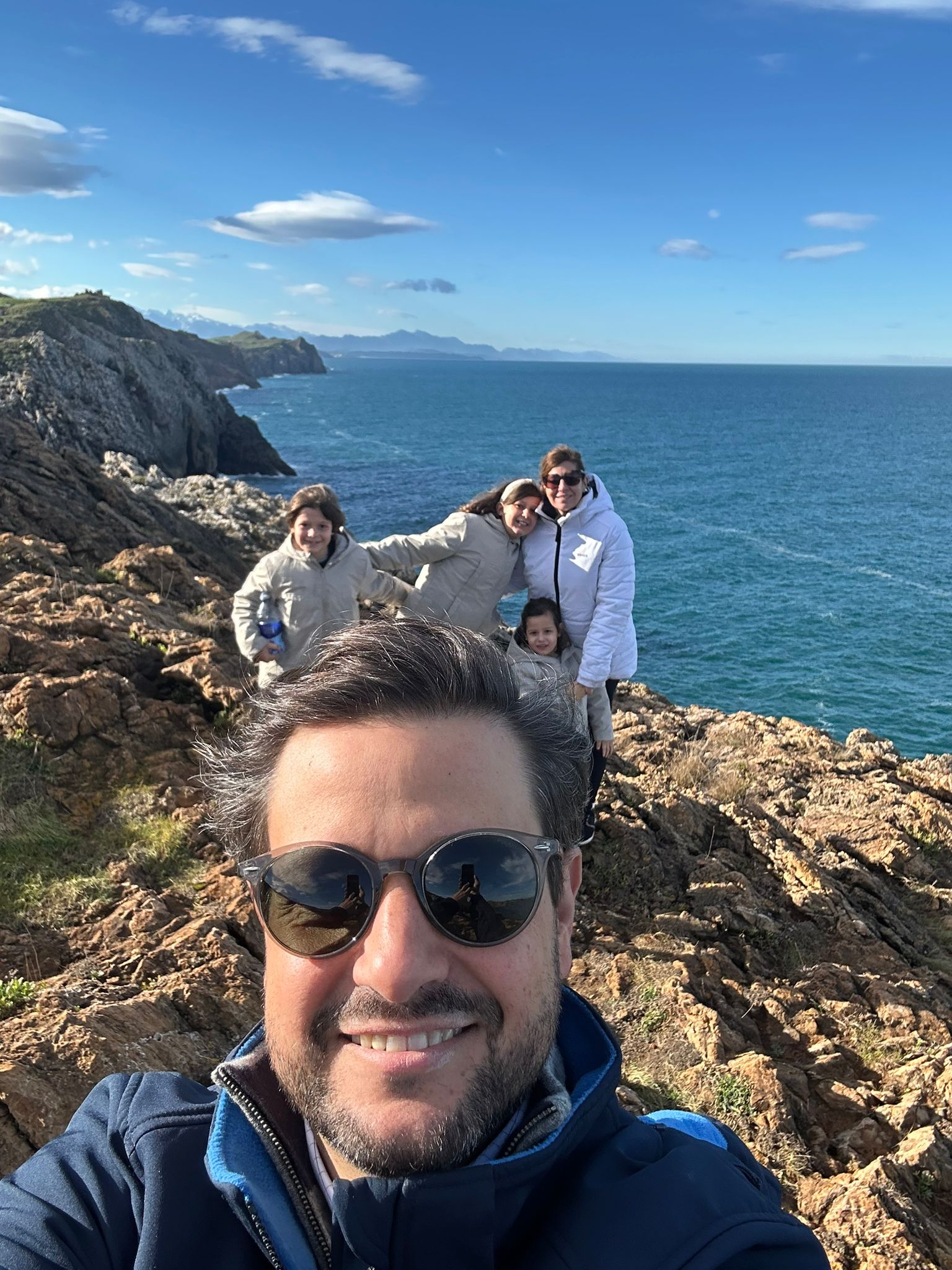 Selfie of Manu Soriano with his family on a Cantabria cliff facing the sea in December 2025