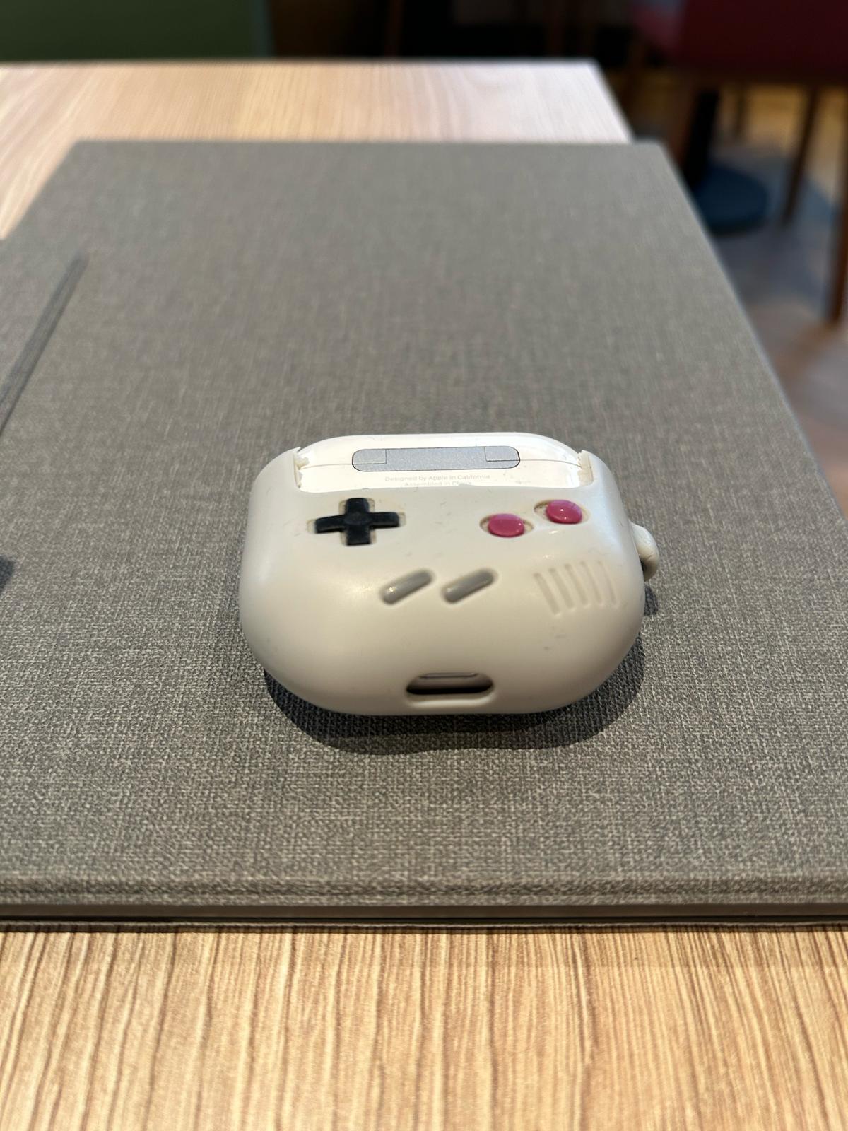 Case shaped like a classic Game Boy controller on a wooden table