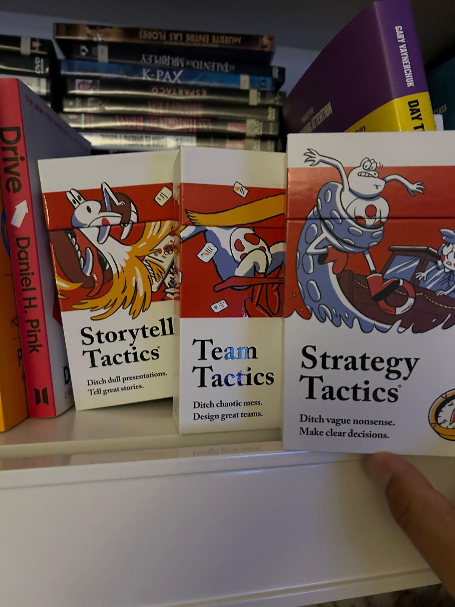 Boxes of the Storytell Tactics, Team Tactics and Strategy Tactics decks next to the book Drive on a shelf