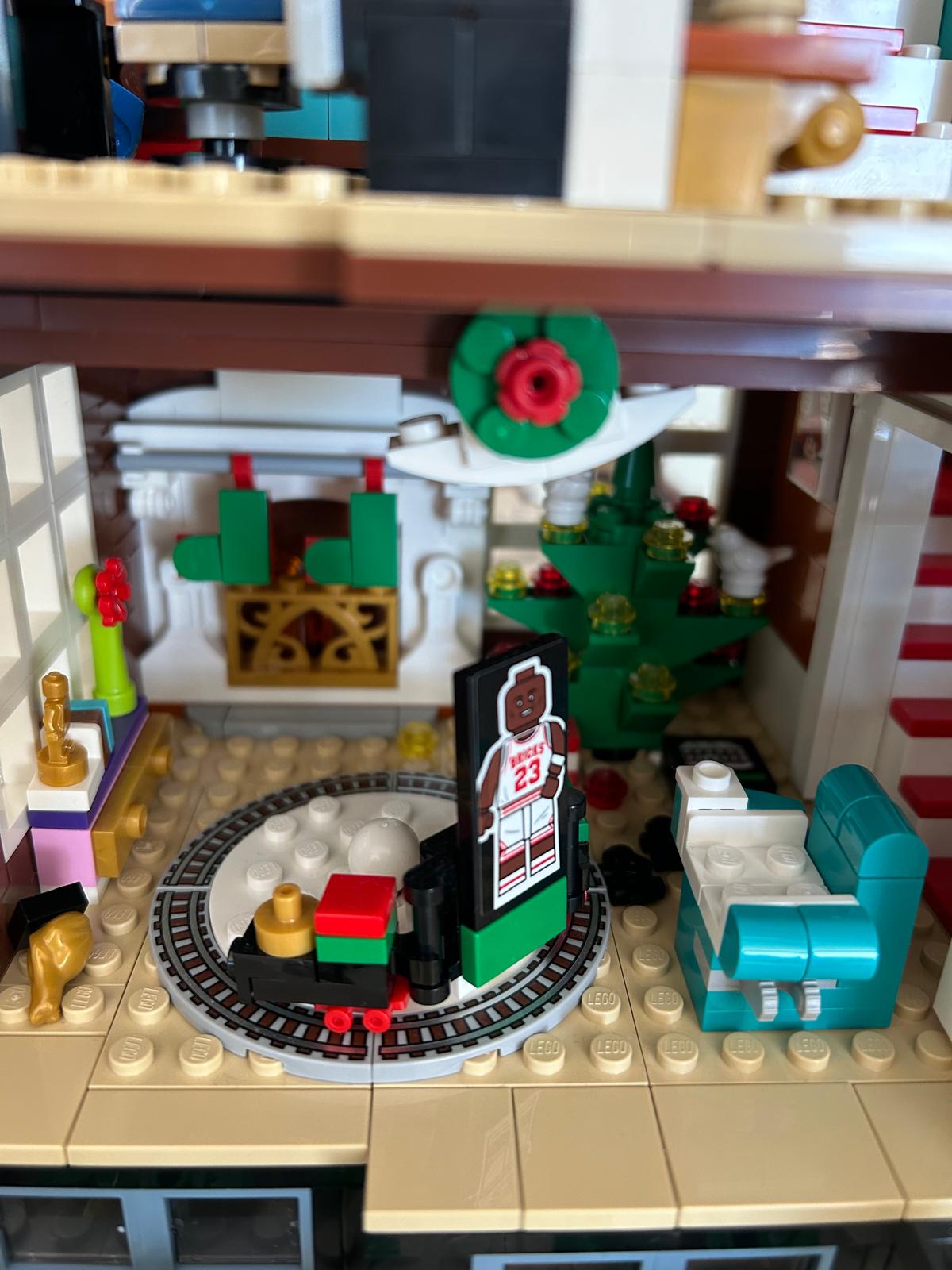 LEGO detail of the living room with a fireplace, Christmas tree and toy train on its tracks