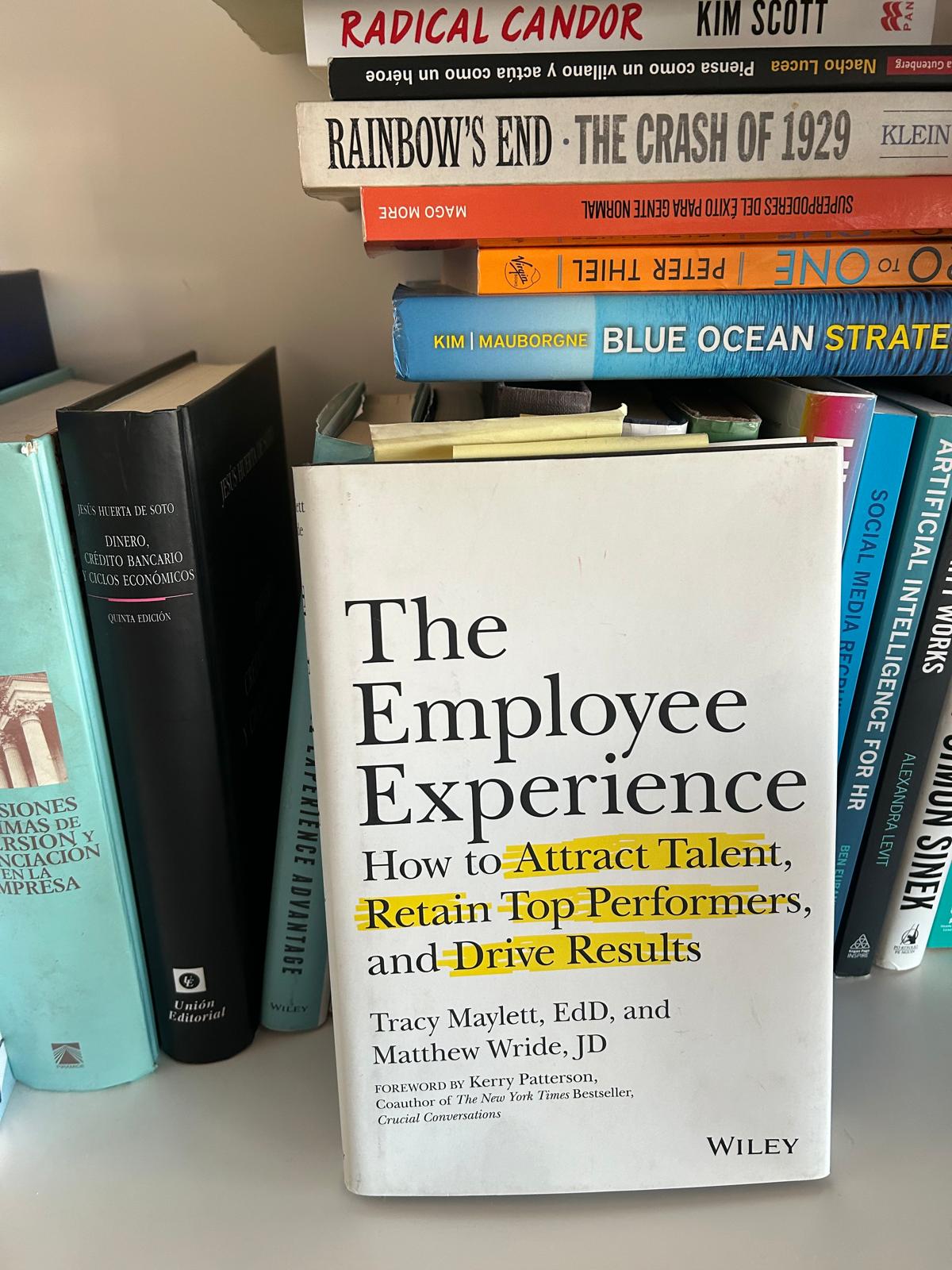 The Employee Experience by Tracy Maylett and Matthew Wride on a shelf next to other management titles