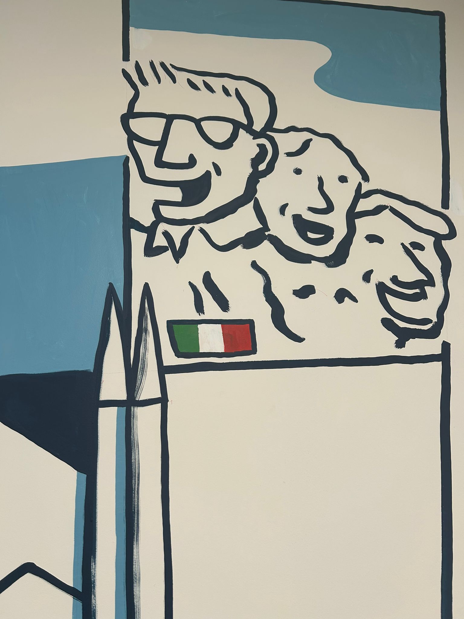Mount Rushmore-style detail of the mural with the faces of W's global board and the Italian flag