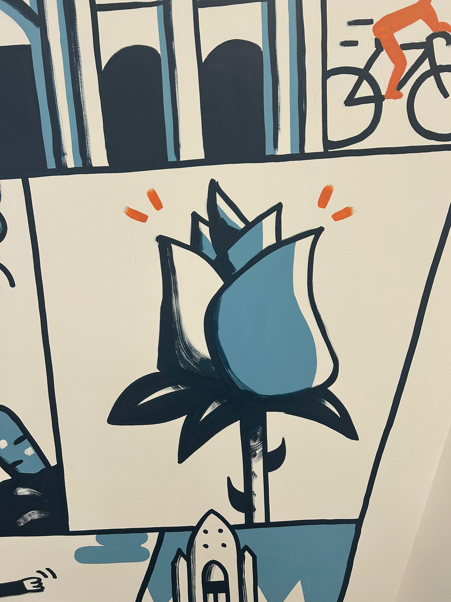 Close-up of the mural's blue rose, a tribute to María Rosa, next to a cyclist